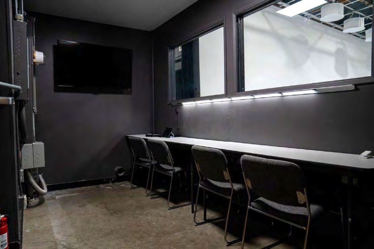DIT room with a long desk and windows onto the stage