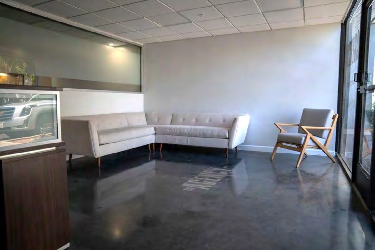 Reception area with a wood desk, brick wall, and sofa