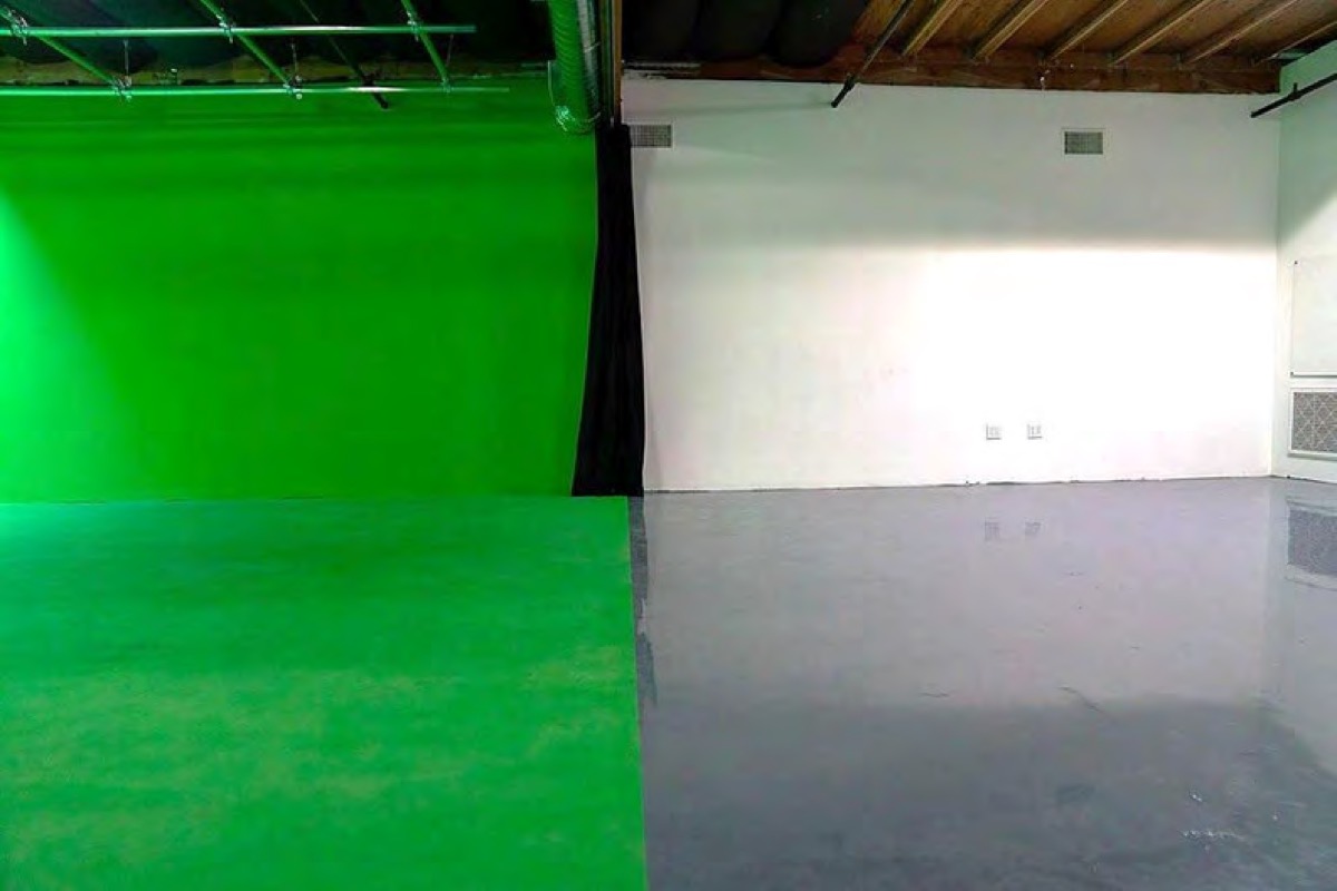 The open staging area beside the green cyc with white walls