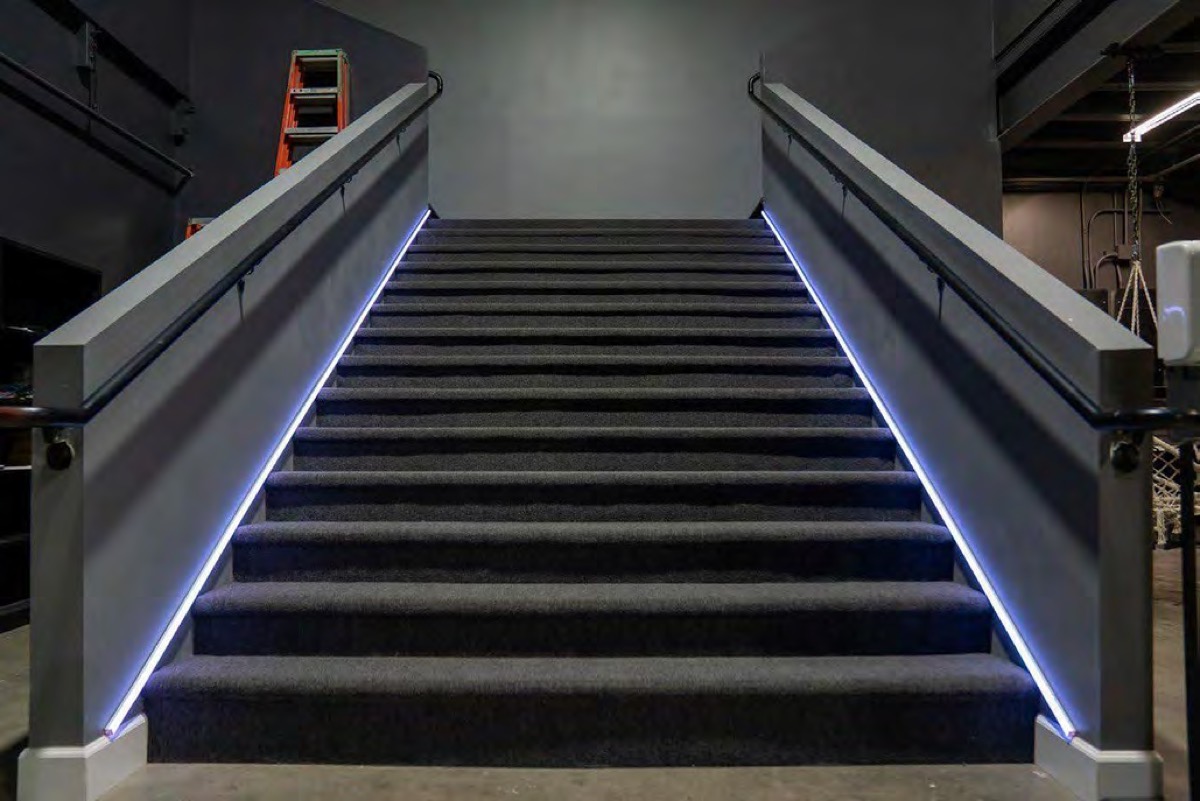 Carpeted mezzanine stairs with LED-lit handrails